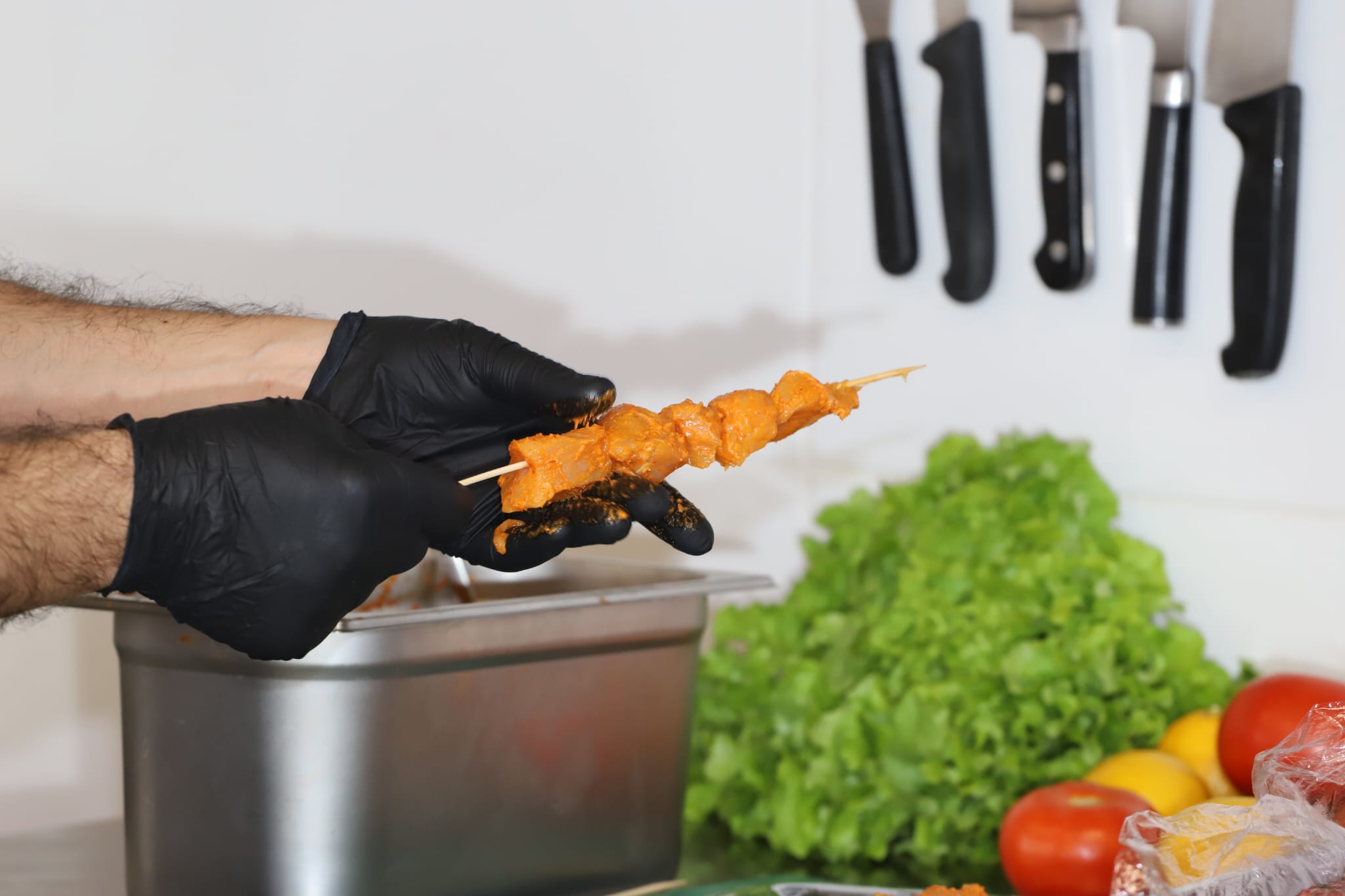 photo du chef Tarek qui prépare des brochettes ce poulet pour la cuisson dans son restaurant Tarbouch